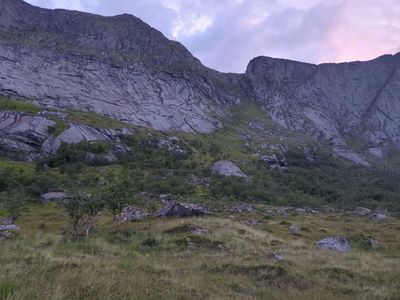 Photo of a mountain pass. A gentle saddle, with green slopes transitioning into grey rock at the top